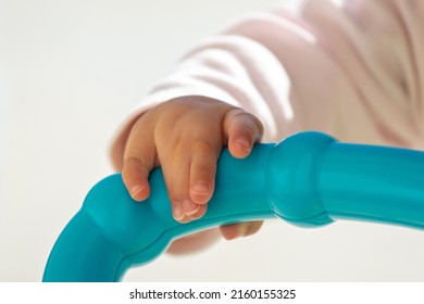 Close Up Of Baby Girl Hands, With Syndactyly, Playing With Green Toy. Medical Condition, Webbed Fingers