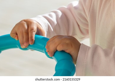 Close Up Of Baby Girl Hands, With Syndactyly, Playing With Green Toy. Medical Condition, Webbed Fingers