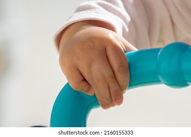 Close Up Of Baby Girl Hands, With Syndactyly, Playing With Green Toy. Medical Condition, Webbed Fingers