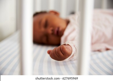 Close Up Of Baby Girl Sleeping In Nursery Cot