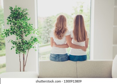 Close Up Back Behind Rear View Photo Two People Mum And Teen Daughter Best Buddies Hold Arms Hugging Motherhood Parenthood Wear White T-shirts Jeans In Bright Flat Sit Comfortable Sofa