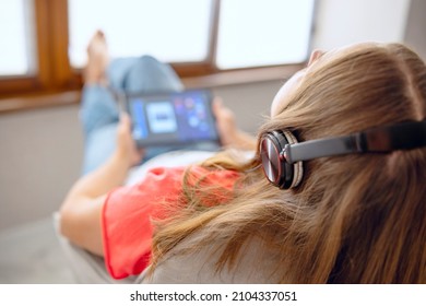 Close Up Back Rear View Calm Young Carefree Woman Enjoying Lounge Free Lazy Weekend Time, Listening To Favorite Music In Headphones Relaxing On Armchair.