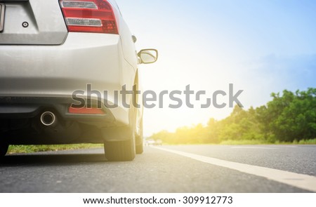 Close up back of  silver car and light on the  road