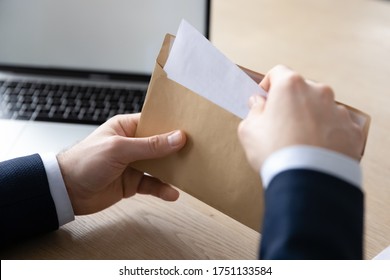 Close up back view of businessman sit at office desk open envelope with postal paper document, male employee unpack post paperwork letter or correspondence with decision notification or law order - Shutterstock ID 1751133584