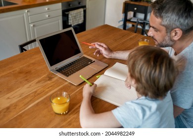 Close Up Back View Of Caring Dad And Teen Son Look At Laptop Screen Study Online For School At Home On Lockdown. Caucasian Father And Schoolboy Child Use Computer Do Homework. Education Concept.