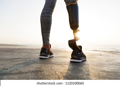 Close up back view of disabled athlete woman with prosthetic leg standing at the beach - Powered by Shutterstock