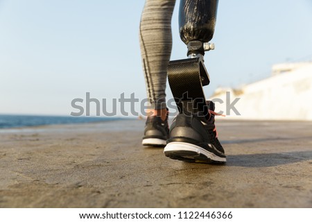 Young female legs walking on the grass