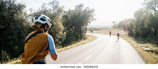 Close Up Back View Of A Female Cyclist During Ride Taking Pictures. Athlete During Summer Vacation Group Ride At Nature Countryside. Space For Text. Beautiful Fit Pretty Cyclist Biking On Nature 