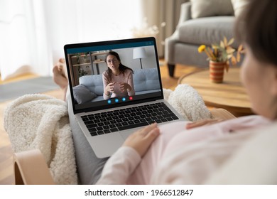 Close Up Back View Of Pregnant Young Woman Talk Speak On Video Call On Laptop With Friend. Over Shoulder View Of Female With Pregnancy Have Digital Virtual Online Consultation On Computer At Home.