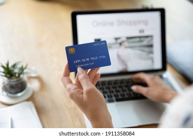 Close Up Back View Of Woman Pay Bills Taxes Online On Laptop From Home With Credit Card. Female Buyer Or Client Shopping Making Payment On Computer Using Secure Banking Service System On Device.