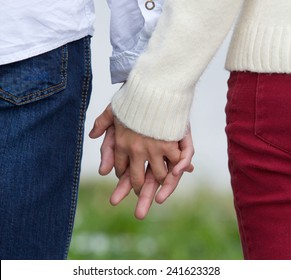 Close up back view of a young couple holding hands - Powered by Shutterstock