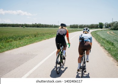 Close Up Back View Of A Young Fit Strong Fast Cyclist During Ride. Athlete During Summer Vacation Group Ride At Nature Countryside. Space For Text. Road Cycling In Action. Training For Competition.