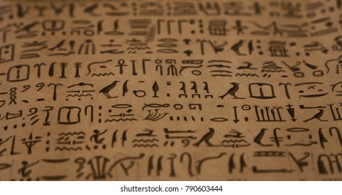 Close up background of ancient Egyptian hieroglyphs written on brown parchment paper, low angle view, selective focus - Shutterstock ID 790603444