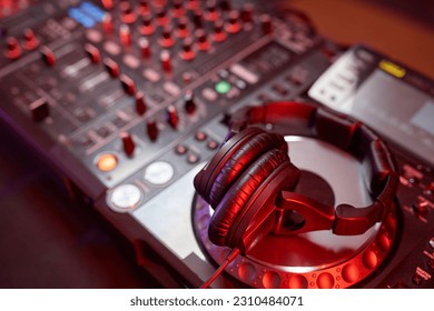 Close up background image of DJ equipment, mixer or turntable in neon light, copy space - Shutterstock ID 2310484071