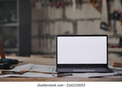 Close up background image of opened laptop with blank white screen on table in workshop, copy space - Powered by Shutterstock