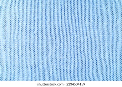 Close up background of knitted wool fabric made of viscose yarn. Pastel blue color wool knitwear texture. Abstract knitted jersey background. Fabric abstract backdrop, wallpaper