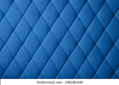 Close up background texture of dark blue genuine leather soft tufted furniture or classic wall panel upholstery with deep diamond pattern