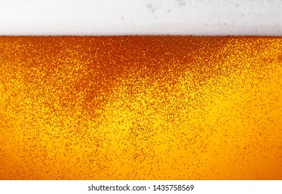 Close Up Background Texture Of Lager Beer With Bubbles And Froth In Glass, Low Angle Side View