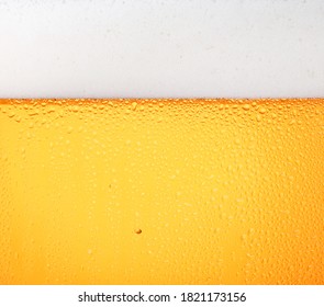 Close Up Background Texture Of Pouring Lager Beer With Bubbles And Froth In Frosty Glass With Drops, Low Angle Side View