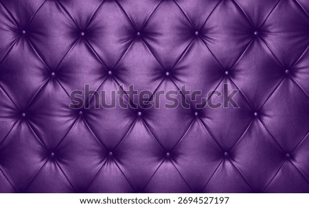 Close up background texture of violet lavender colored capitone genuine leather, retro Chesterfield style soft tufted furniture upholstery with deep diamond pattern and buttons