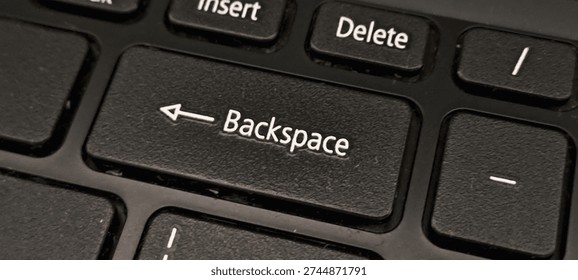 Close up of the backspace key on a keyboard. Macro shot of the backspace button on a black laptop keyboard. Symbol of correction, deleting errors and editing text