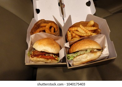 Close up Bacon cheese burger with deep fried onion rings and crinkle cut French fries - Powered by Shutterstock