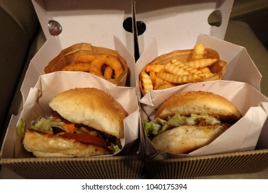 Close up Bacon cheese burger with onion rings and crinkle cut fries - Powered by Shutterstock