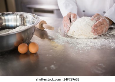 Close up of baker preparing dough in the kitchen of the bakery - Powered by Shutterstock