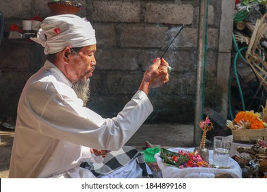 Close up of a Balinese pedanda during prayer. side view of a hindu priest performing a ceremony. A hindu priest performing offerings in a temple in Pemuteran in Bali, Indonesia.