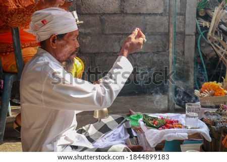Close up of a Balinese pedanda during prayer. side view of a hindu priest performing a ceremony. A hindu priest performing offerings in a temple in Pemuteran in Bali, Indonesia.