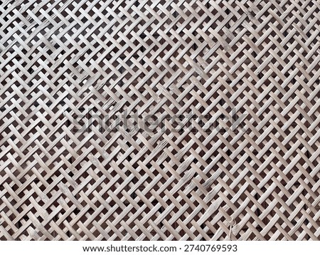 Close up bamboo weave texture background, natural rattan pattern with crisscross design, handmade craft surface in neutral brown tone.