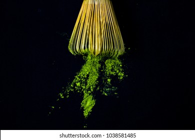 Close Up Bamboo Whisk And Matcha Green Tea Powder On Black Background.