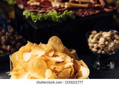 Close up of banquet table with different food Salty snacks. Pretzels, chips, crackers. Walnut, pistachios, almonds, hazelnuts and cashews - Shutterstock ID 1533221777