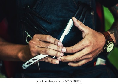 Close Up Of Barber Testing The Sharpness Of A Blade.