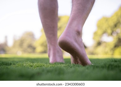 Cercano a los pies desnudos caminando sobre la hierba, avanzar en concepto, crecimiento de negocios, activo, relajante