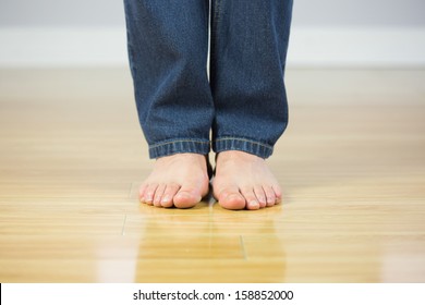 Close Up Of Bare Male Feet On Wooden Floor