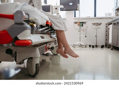 Close up of barefoot legs of patient, sitting on hospital bed in emergency room. Anxiety, worry and loneliness of patient in hospital. - Powered by Shutterstock