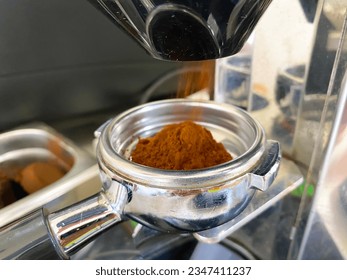 close up barista grinder coffee machine. Roasted coffee beans are ground in a coffee grinder