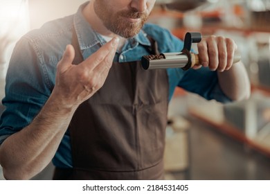 Close up of barista inhaling the aroma of coffee in own manufacturing of roasted coffee beans - Powered by Shutterstock