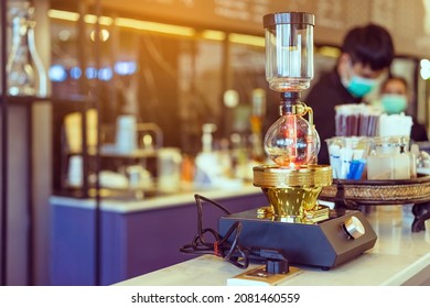 Close Up To Barista Make Coffee With Vacuum Pot Syphon Brewer.  Syphon (Siphon) Coffee Maker Brews Drink Using Two Chambers Where Vapor Pressure And Vacuum Produce Coffee In Cafe. Selective Focus.