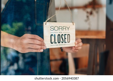 Close. barista, waitress man turning Closed sign board on glass door in modern cafe coffee shop, cafe restaurant, retail store, small business owner, food and drink concept - Powered by Shutterstock