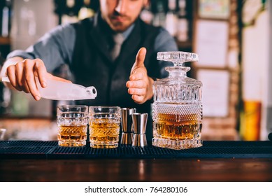 Close Up Of Barman Hands Adding Ice And Whiskey To Modern Urban Cocktails. Sky Bar Serving Elegant Drinks