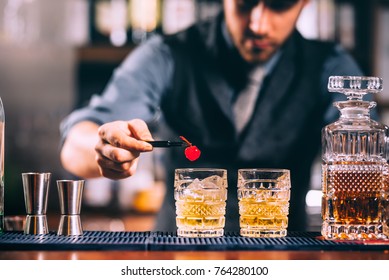 Close Up Of Bartender Hands Preparing Old Fashioned Whiskey Cocktail On Bar Counter