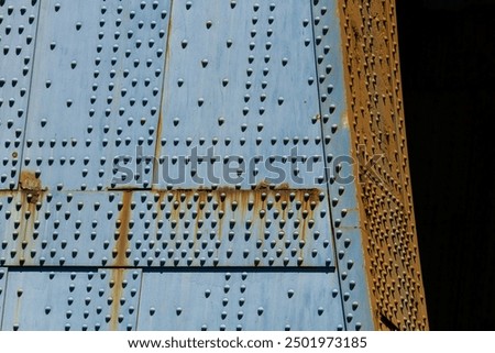 Close up of the base of the Manhattan Bridge highlighting the pattern of rivets in the blue steel