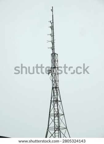 Close up of a Base Transceiver Station (BTS) telecommunications tower supporting cellular antennas and wireless communication equipment against a clear blue sky. Ideal for mobile networks, telecommunications, digital connectivity, 4G, 5G, and infrastructure concepts.
