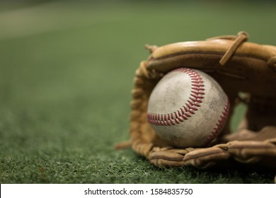 Close Up Of Baseball In Mitt On Turf