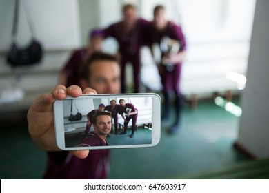 Close up of baseball team clicking selfie while standing at locker room after match - Powered by Shutterstock