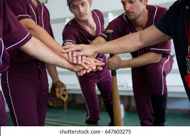 Close up of baseball team doing high five while standing at locker room - Powered by Shutterstock