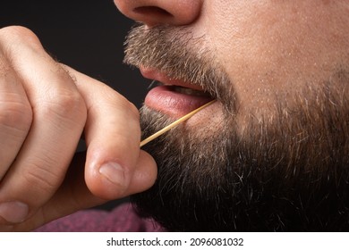 Close Up Bearded Man Clean Teeth From Food Stuck Her Teeth With Toothpick After Breakfast, Lunch, Dinner. Rude Behavior. Uncultured And Impolite Habit