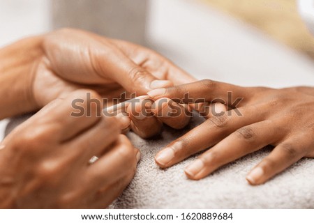 Similar – Woman filing nails in colored background